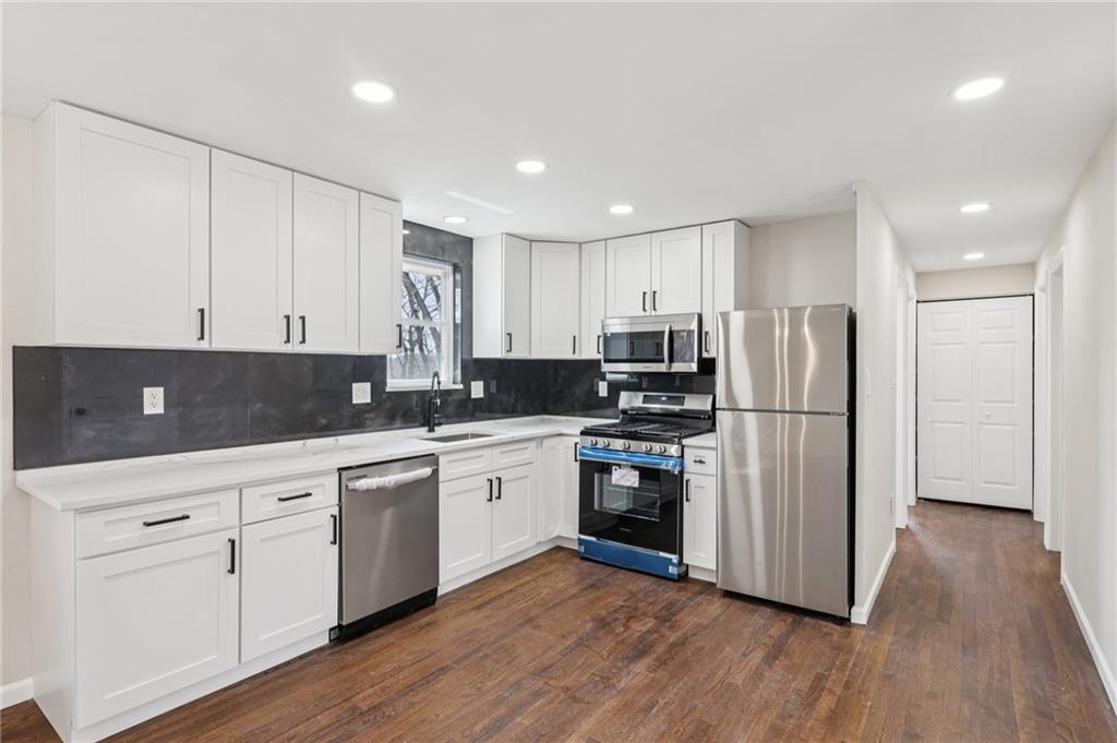 826 Blue Ridge Road Pittsburgh, PA 15239 - Photo 11 of 26 a kitchen with stainless steel appliances granite countertop a refrigerator a sink dishwasher a stove and white cabinets with wooden floor