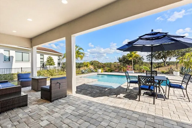 a view of a patio with table and chairs with wooden floor and fence