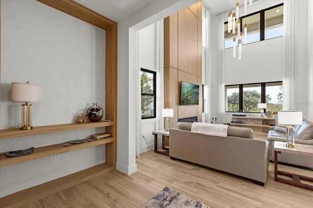 a view of a hallway with wooden floor and a living room