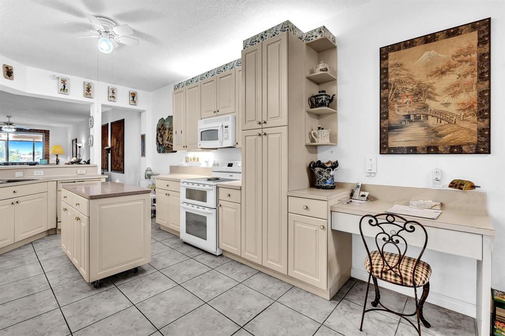 7715 Southampton Terrace, Unit 301 Tamarac, FL 33321 - Photo 10 of 76 a kitchen with white cabinets and white appliances