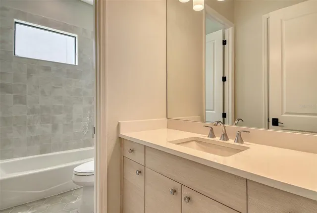 a bathroom with a granite countertop sink a toilet and a bathtub