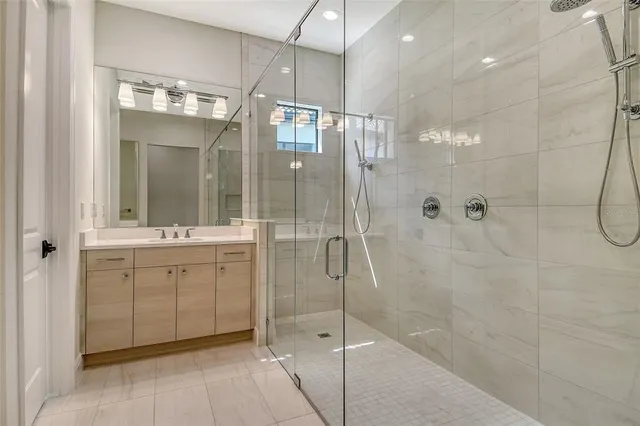 a bathroom with a shower sink and mirror