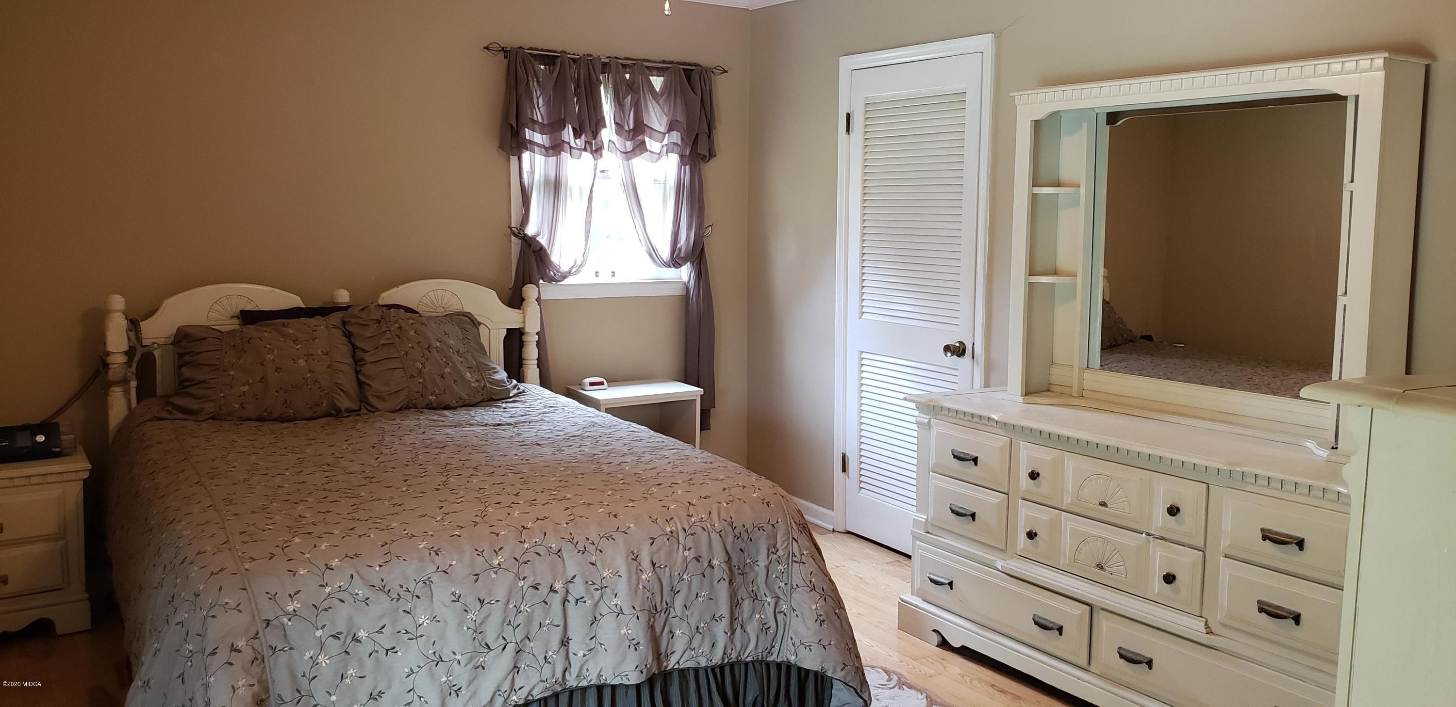 291 Morton Road Gray, GA 31032 - Photo 18 of 33 a bedroom with a bed and a closet with mirror