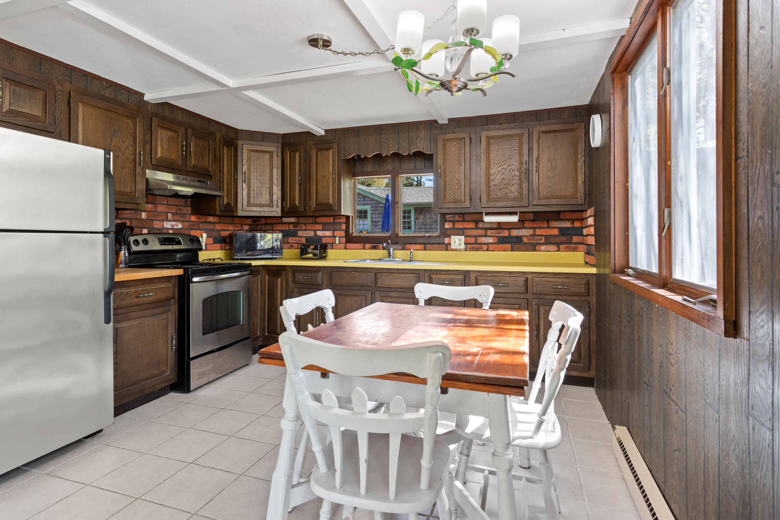 14 Greenwood Road Mashpee, MA 02649 - Photo 20 of 25 a dining room filled chandelier and kitchen view