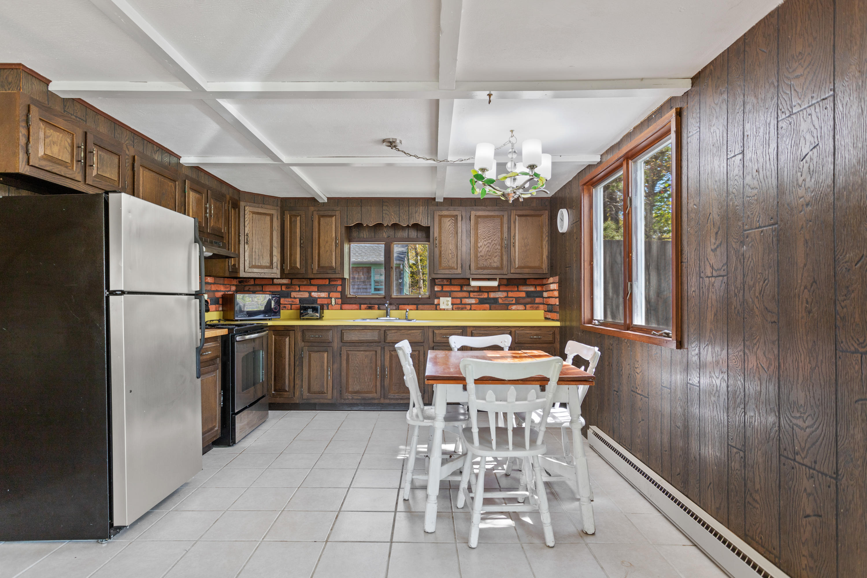 14 Greenwood Road Mashpee, MA 02649 - Photo 3 of 25 a kitchen with stainless steel appliances a refrigerator a sink dishwasher a dining table and chairs with wooden floor
