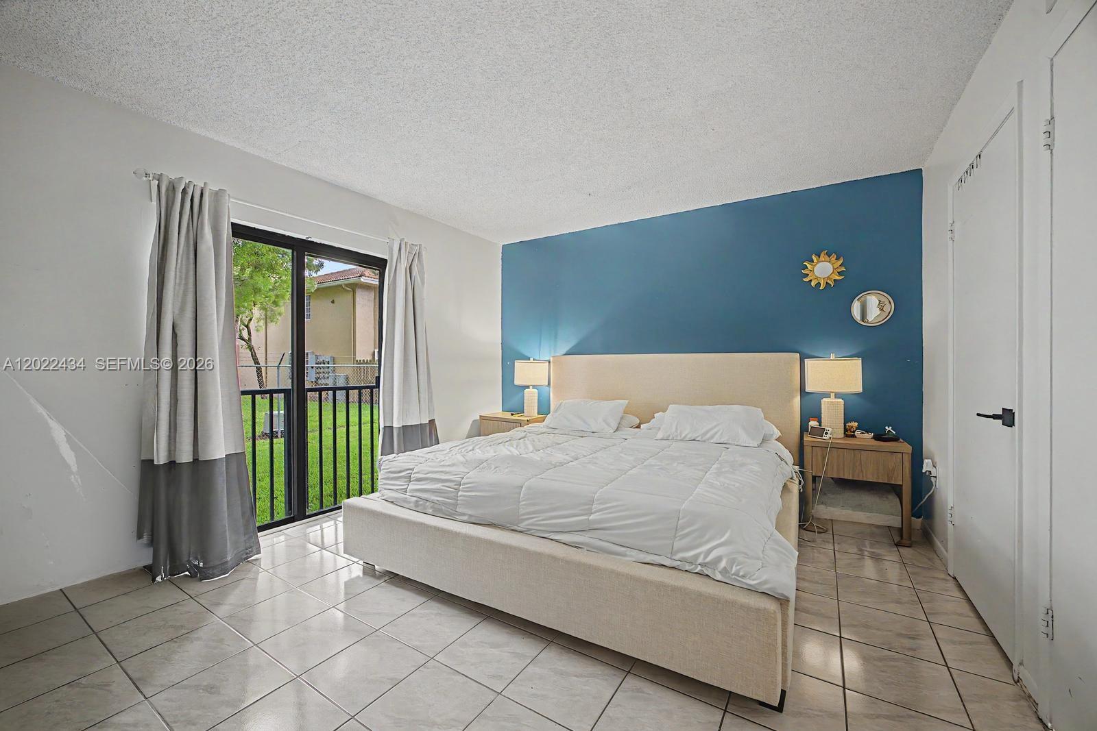 13045 Southwest 68th Street, Unit 111 Miami, FL 33183 - Photo 8 of 15 a spacious bedroom with a bed and a window