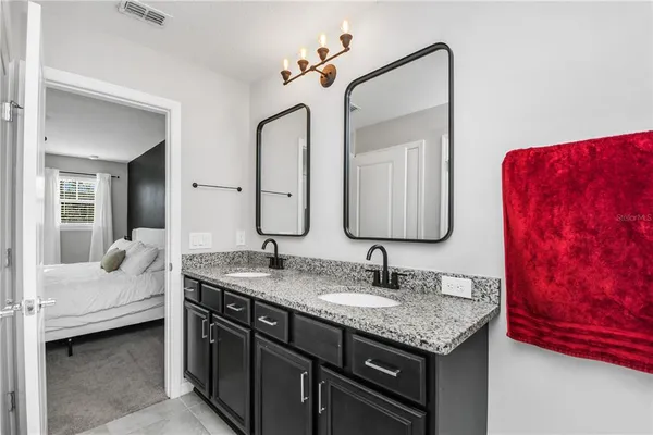 a bathroom with a granite countertop sink and a mirror