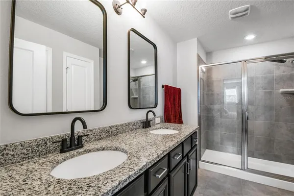 a bathroom with double vanity sinks and a mirror