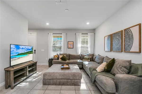 a living room with furniture a flat screen tv and a window