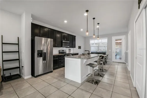 a kitchen with a refrigerator and a stove top oven
