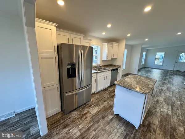 a kitchen with stainless steel appliances granite countertop a refrigerator a sink and a stove