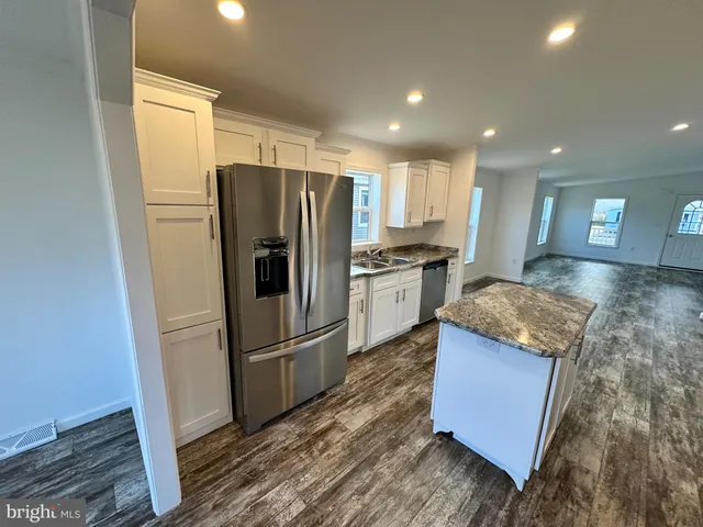 a kitchen with stainless steel appliances granite countertop a refrigerator a sink and a stove