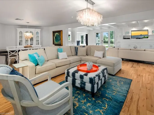 a living room with furniture a chandelier and a fireplace