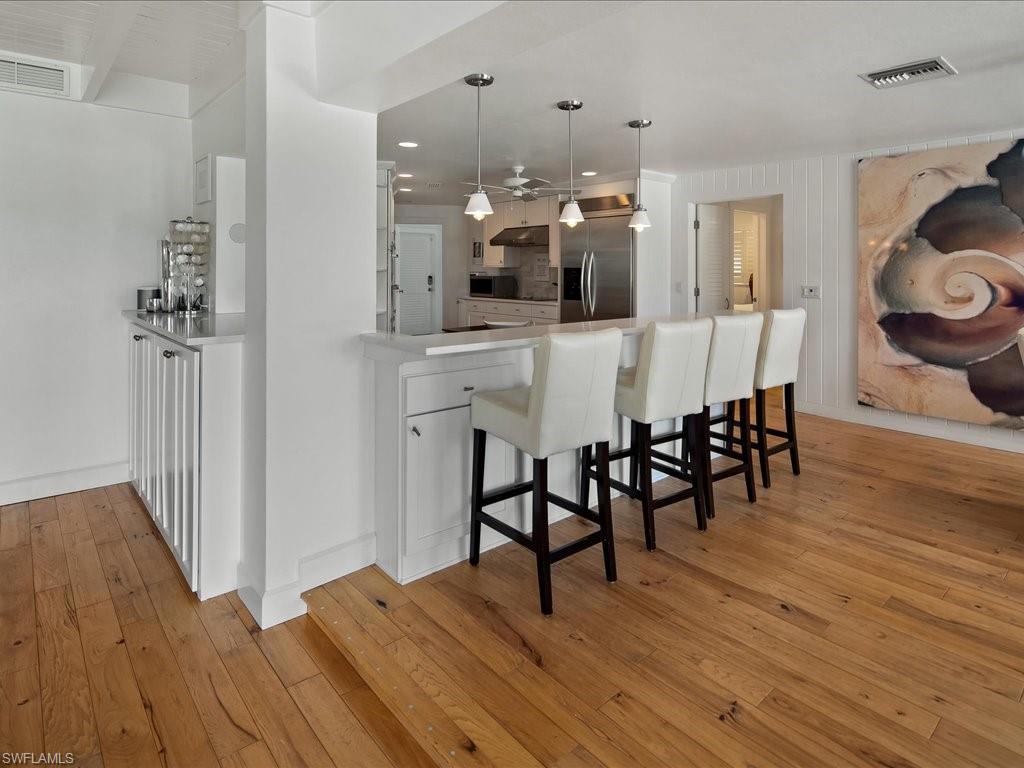 436 Golfview Drive Naples, FL 34110 - Photo 16 of 44 a view of a dining room with furniture and wooden floor