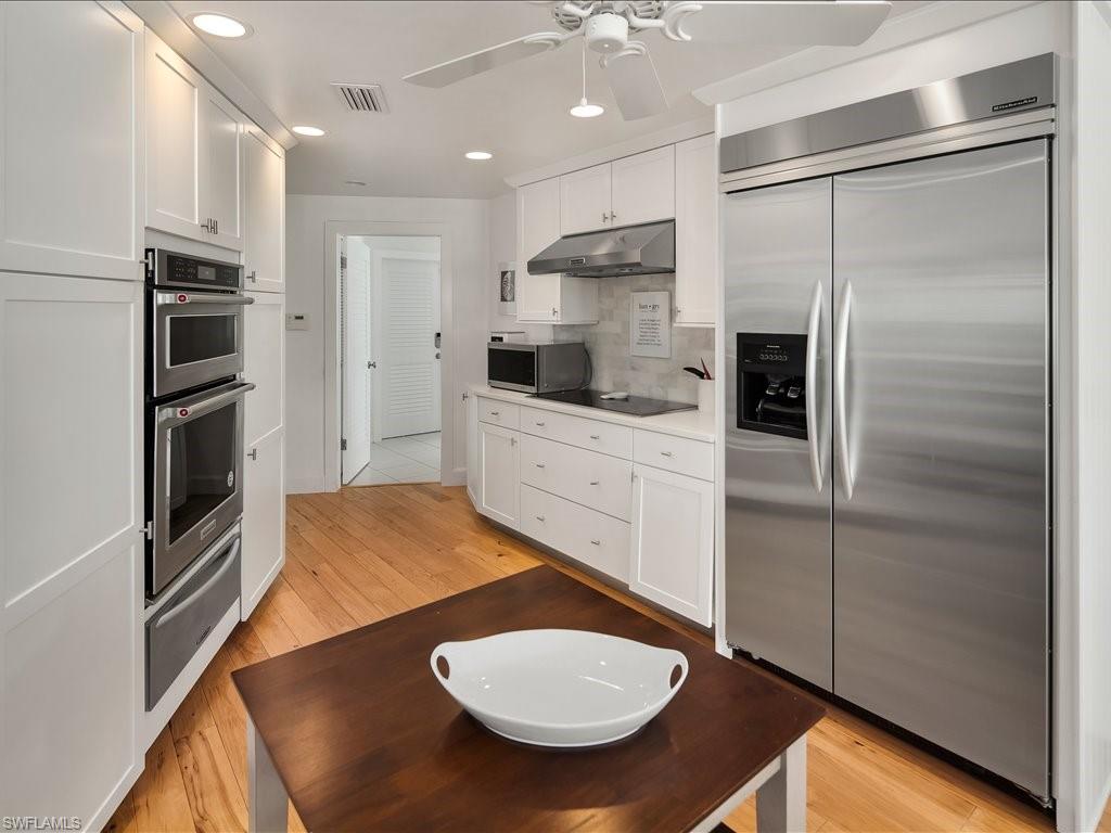 436 Golfview Drive Naples, FL 34110 - Photo 18 of 44 a kitchen with stainless steel appliances a refrigerator and a stove top oven