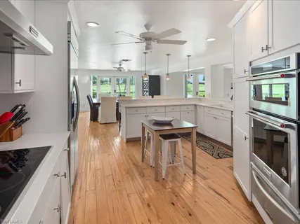 a kitchen with stainless steel appliances kitchen island granite countertop a stove a sink and a refrigerator