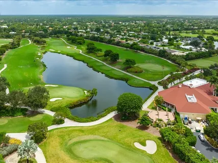 an aerial view of a residential houses with outdoor space and a lake view