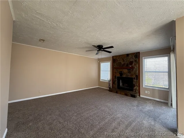 an empty room with a fireplace and cabinet