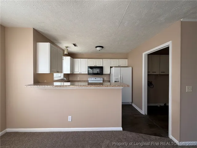 a view of kitchen with refrigerator stove and microwave