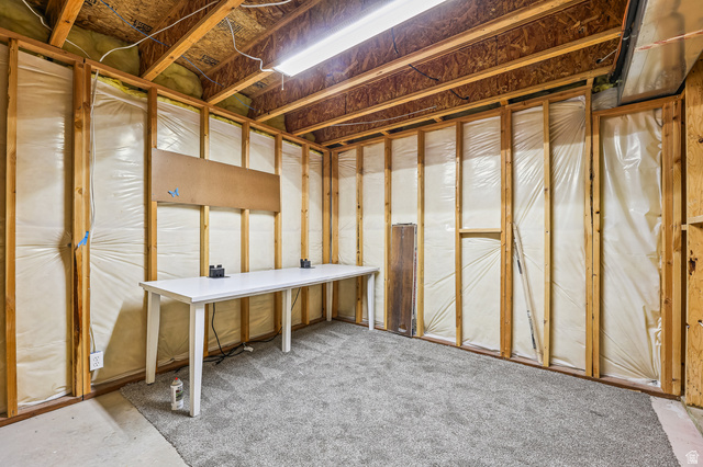 5525 Hampton Way Stansbury Park, UT 84074 - Photo 30 of 35 Unfinished basement area featuring exposed wood framing, ceiling joists, and a partial gray carpet installation