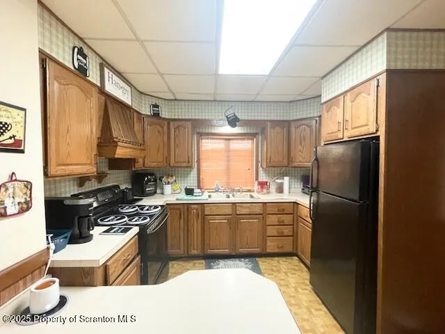 a kitchen with a refrigerator a sink a stove a washer dryer and cabinets