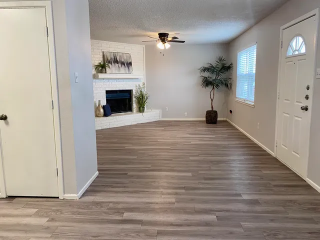 a view of an empty room with a fireplace and a mirror