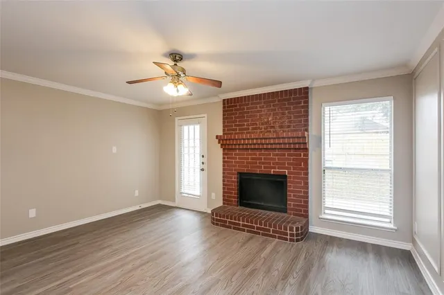an empty room with windows and fireplace