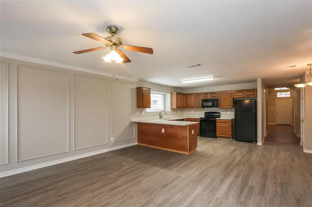 a large kitchen with cabinets wooden floor and stainless steel appliances