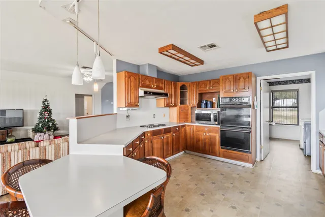 a kitchen with stainless steel appliances kitchen island granite countertop a table and chairs in it