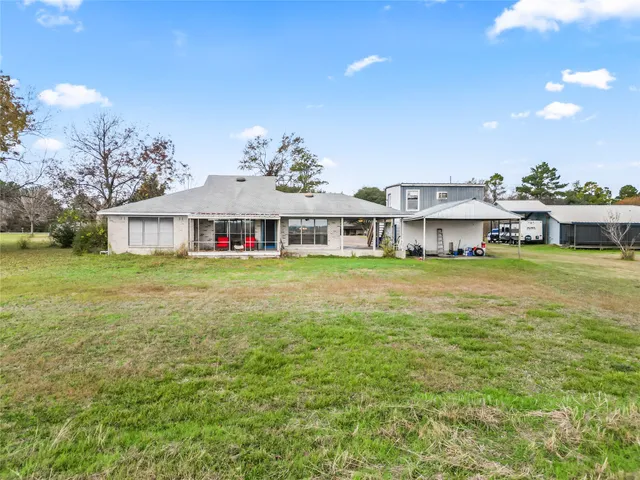 a view of a house with a big yard and large trees