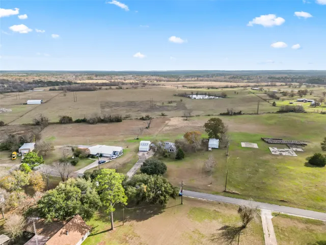 an aerial view of ocean and residential houses with outdoor space
