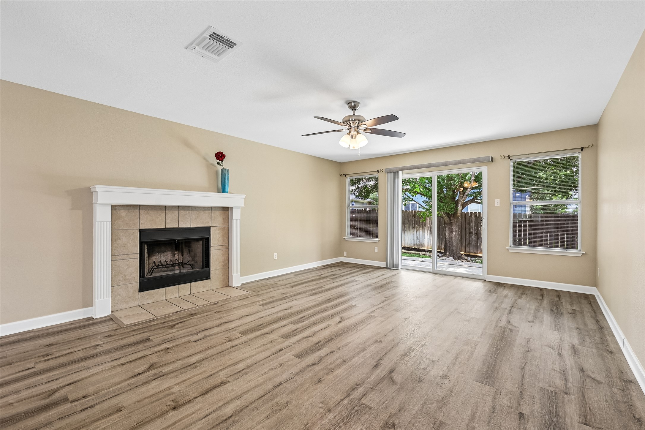 152 Grant Way Kyle, TX 78640 - Photo 11 of 39 a view of an empty room with wooden floor and a fireplace