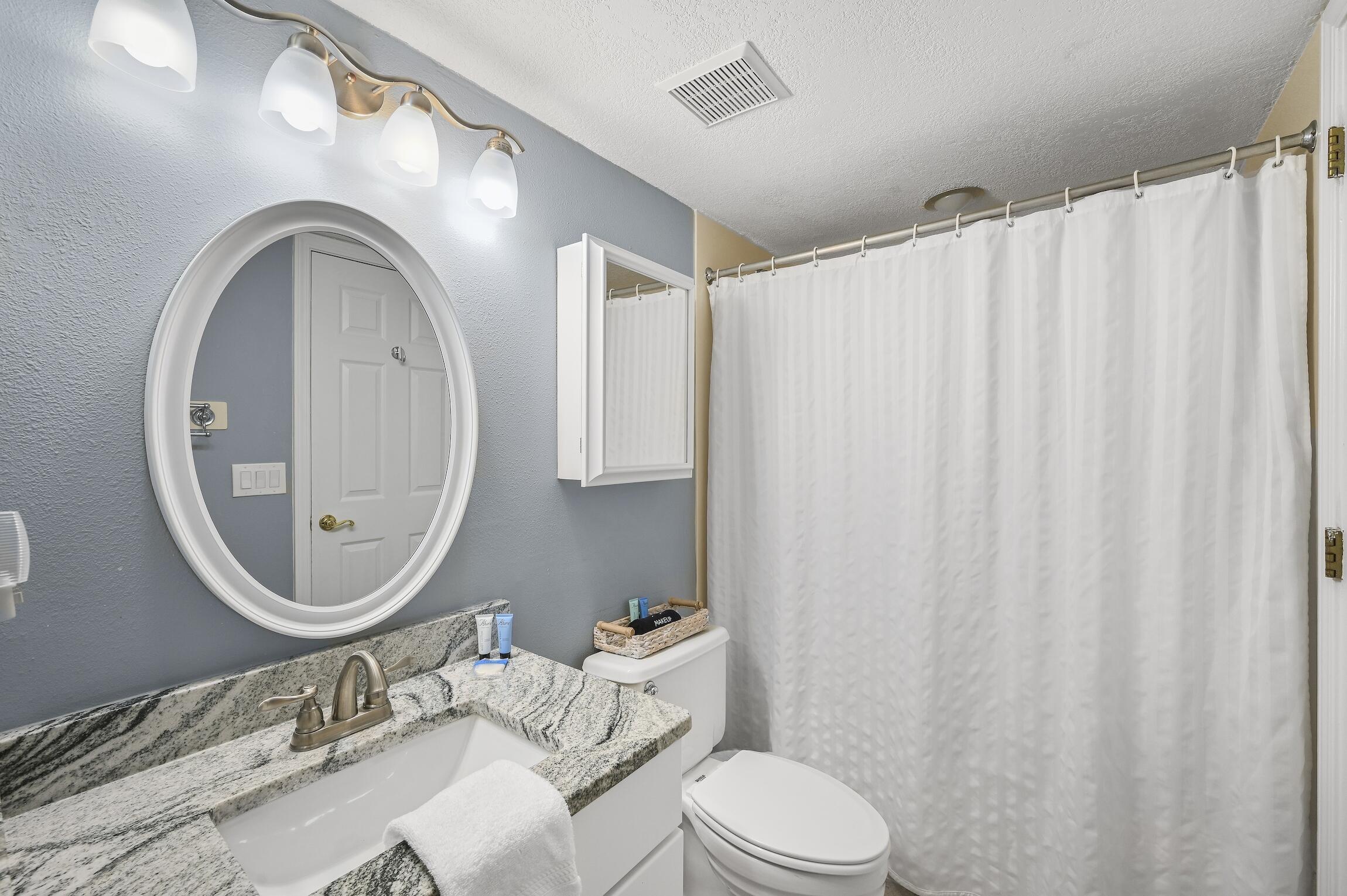 1040 Highway 98, Unit 802 Destin, FL 32541 - Photo 12 of 27 a bathroom with a toilet a sink and a mirror