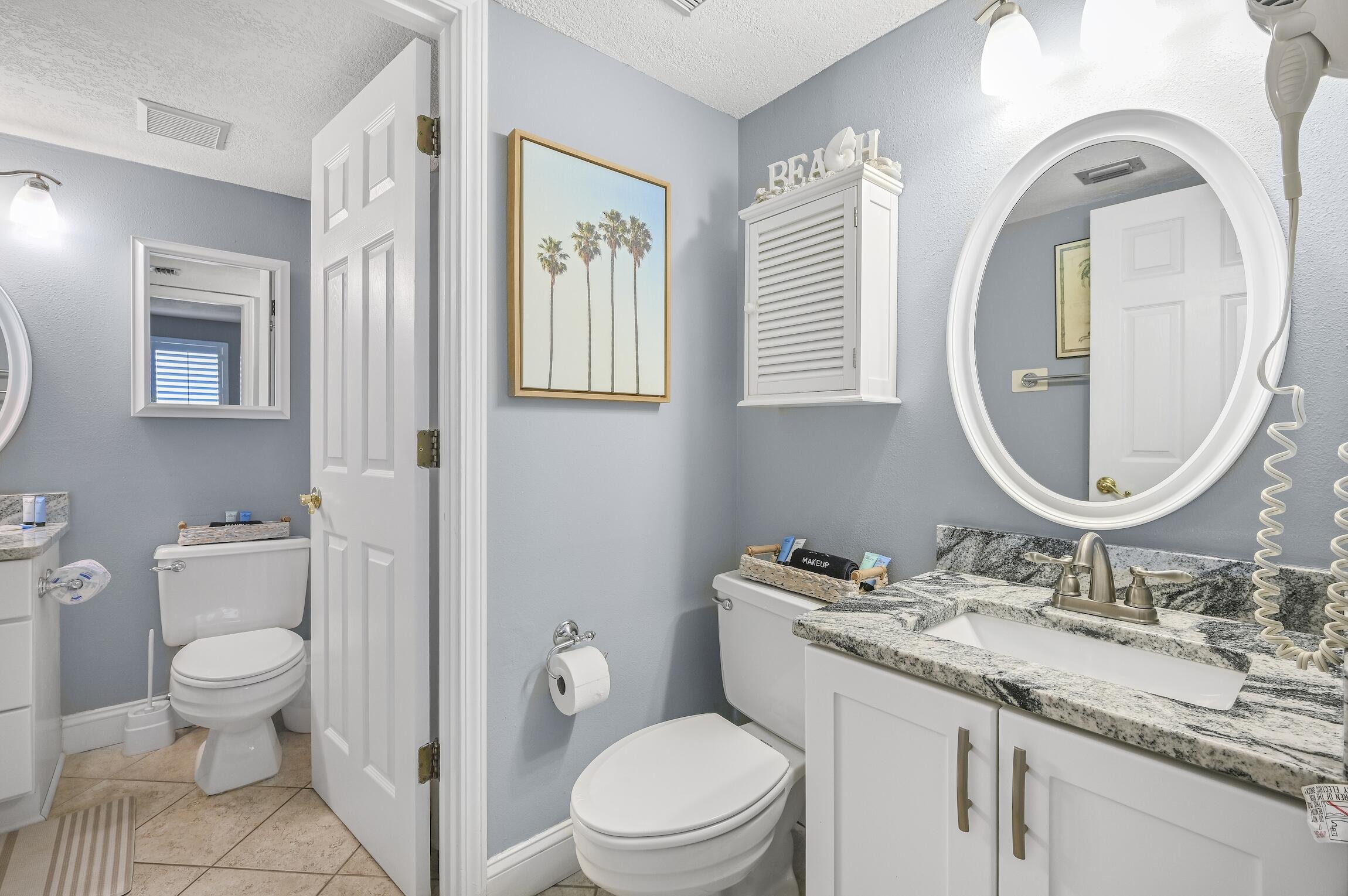 1040 Highway 98, Unit 802 Destin, FL 32541 - Photo 13 of 27 a bathroom with a granite countertop toilet a sink and a mirror