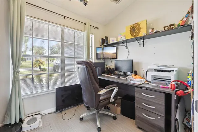 a view of a workspace with furniture and a window