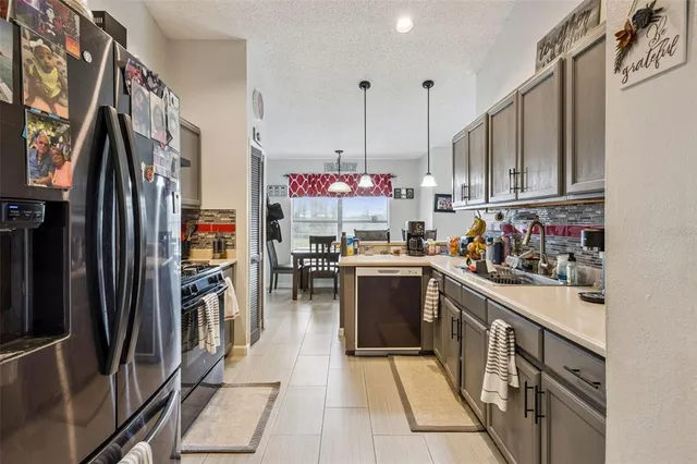 a kitchen with stainless steel appliances granite countertop a refrigerator and a stove