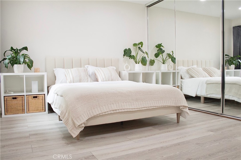 2052 South June Place Anaheim, CA 92802 - Photo 5 of 12 a large white bed sitting in a bedroom next to a window with potted plants