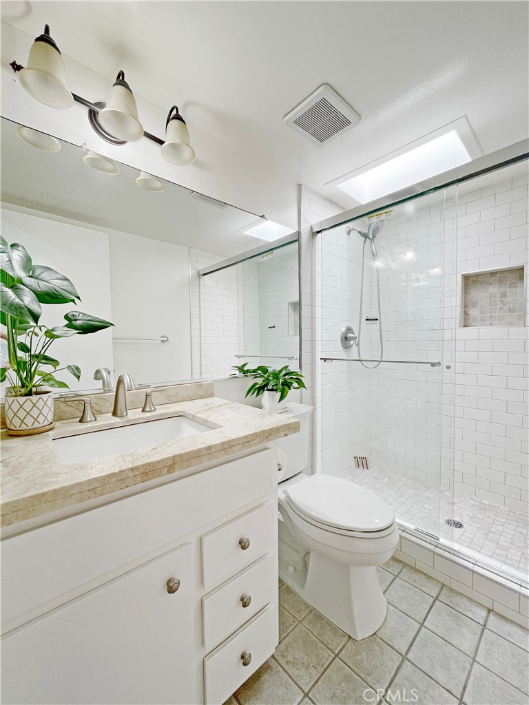 2052 South June Place Anaheim, CA 92802 - Photo 8 of 12 a bathroom with a granite countertop sink a toilet and shower