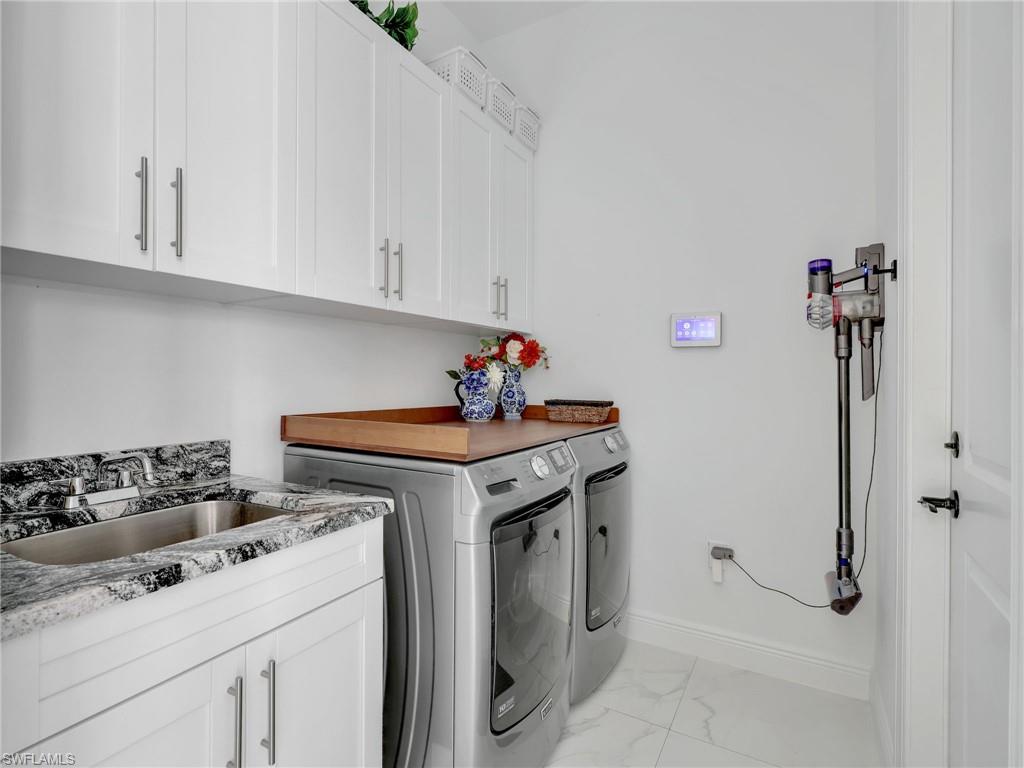 2007 22nd Avenue Northeast Naples, FL 34120 - Photo 26 of 47 Laundry Room With White Shaker Cabinetry, Quartz Counter With Stainless Steel Sink , & Maytag Front Load Washer & Dryer