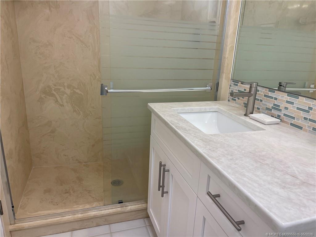 1858 Southwest Palm City Road, Unit 203 Stuart, FL 34994 - Photo 20 of 21 a bathroom with a granite countertop sink and a mirror