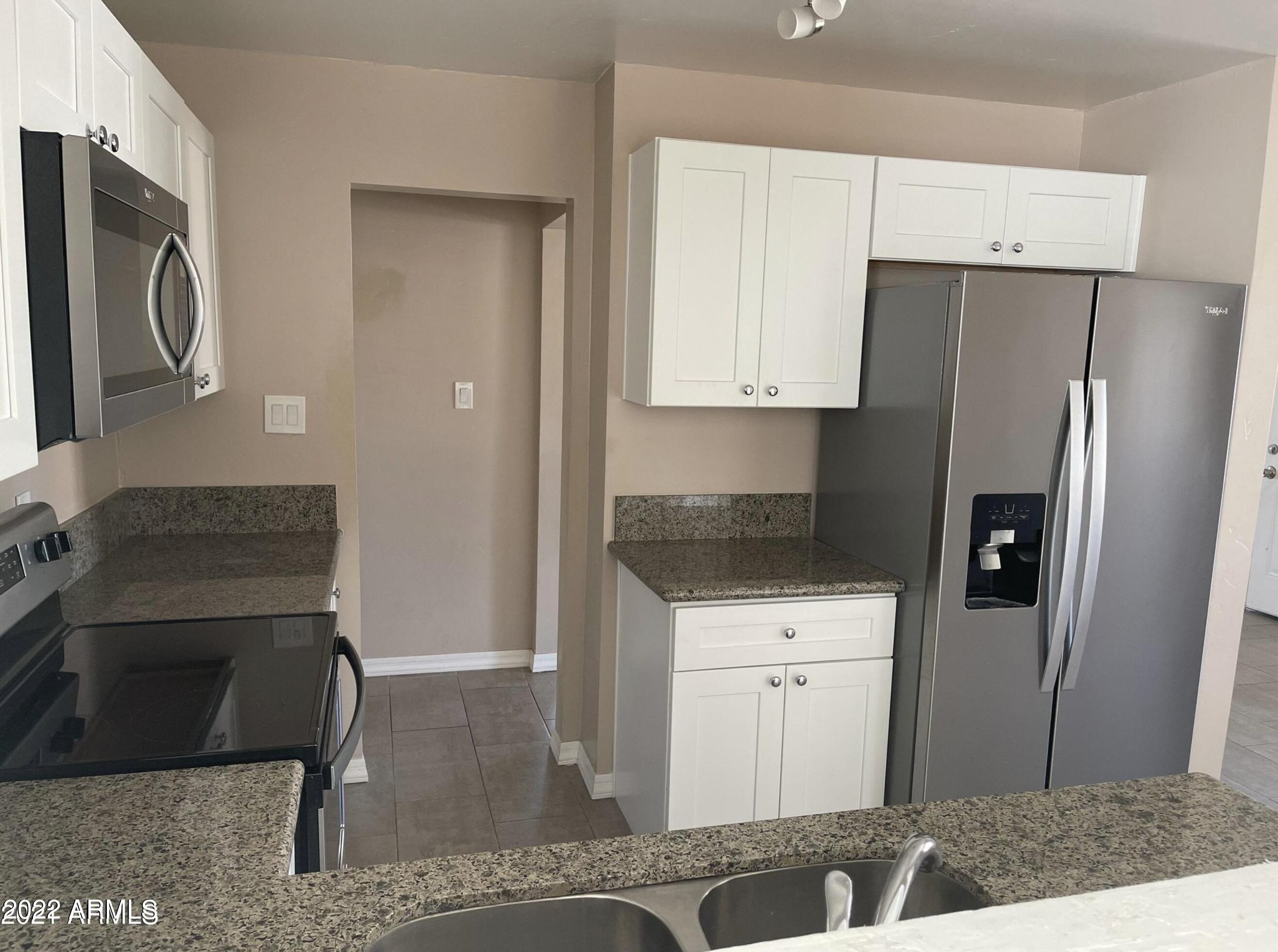 4609 East Almeria Road Phoenix, AZ 85008 - Photo 3 of 8 a kitchen with stainless steel appliances granite countertop a refrigerator a stove and a sink