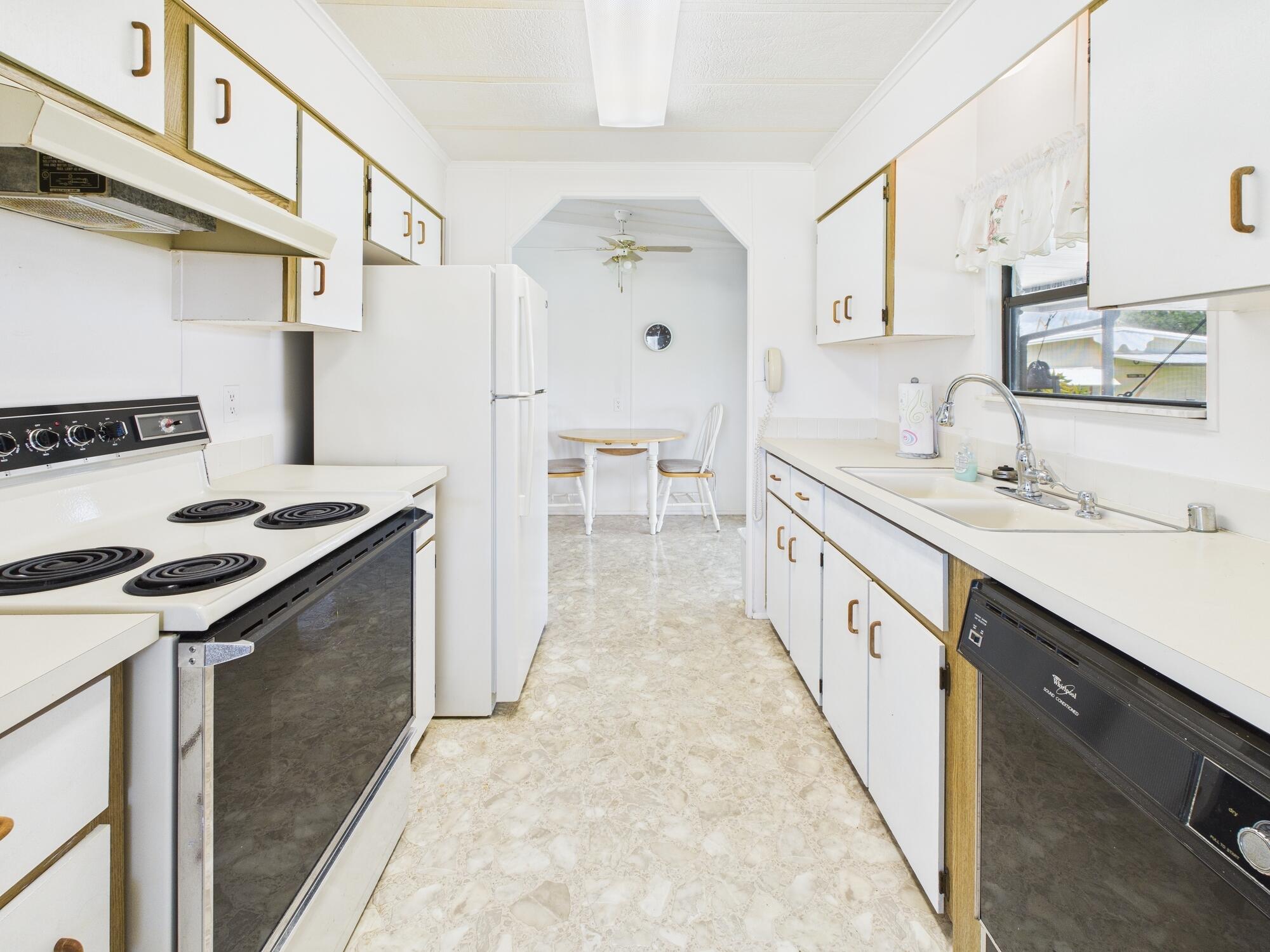 2001 Southeast 27th Street Okeechobee, FL 34974 - Photo 16 of 57 a kitchen with granite countertop a sink stove and cabinets