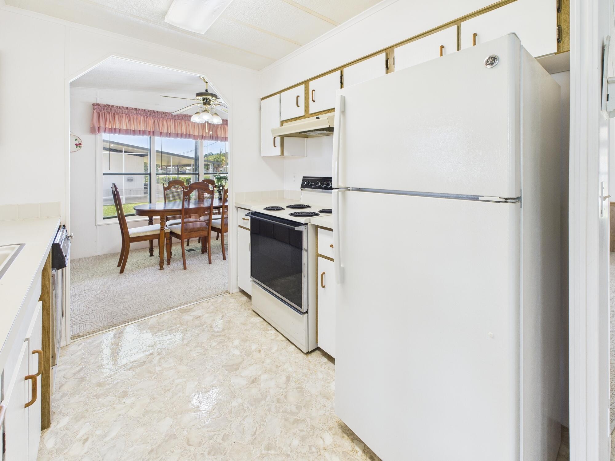 2001 Southeast 27th Street Okeechobee, FL 34974 - Photo 19 of 57 a kitchen with stainless steel appliances granite countertop a refrigerator and a table