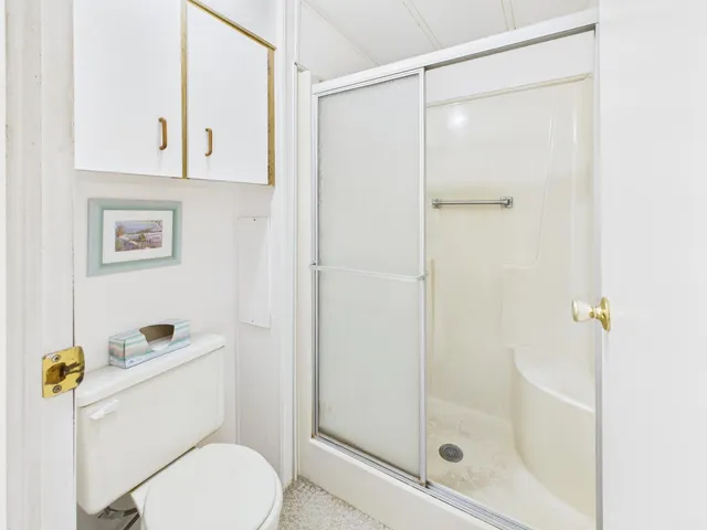 a bedroom with a bed a chandelier and a window