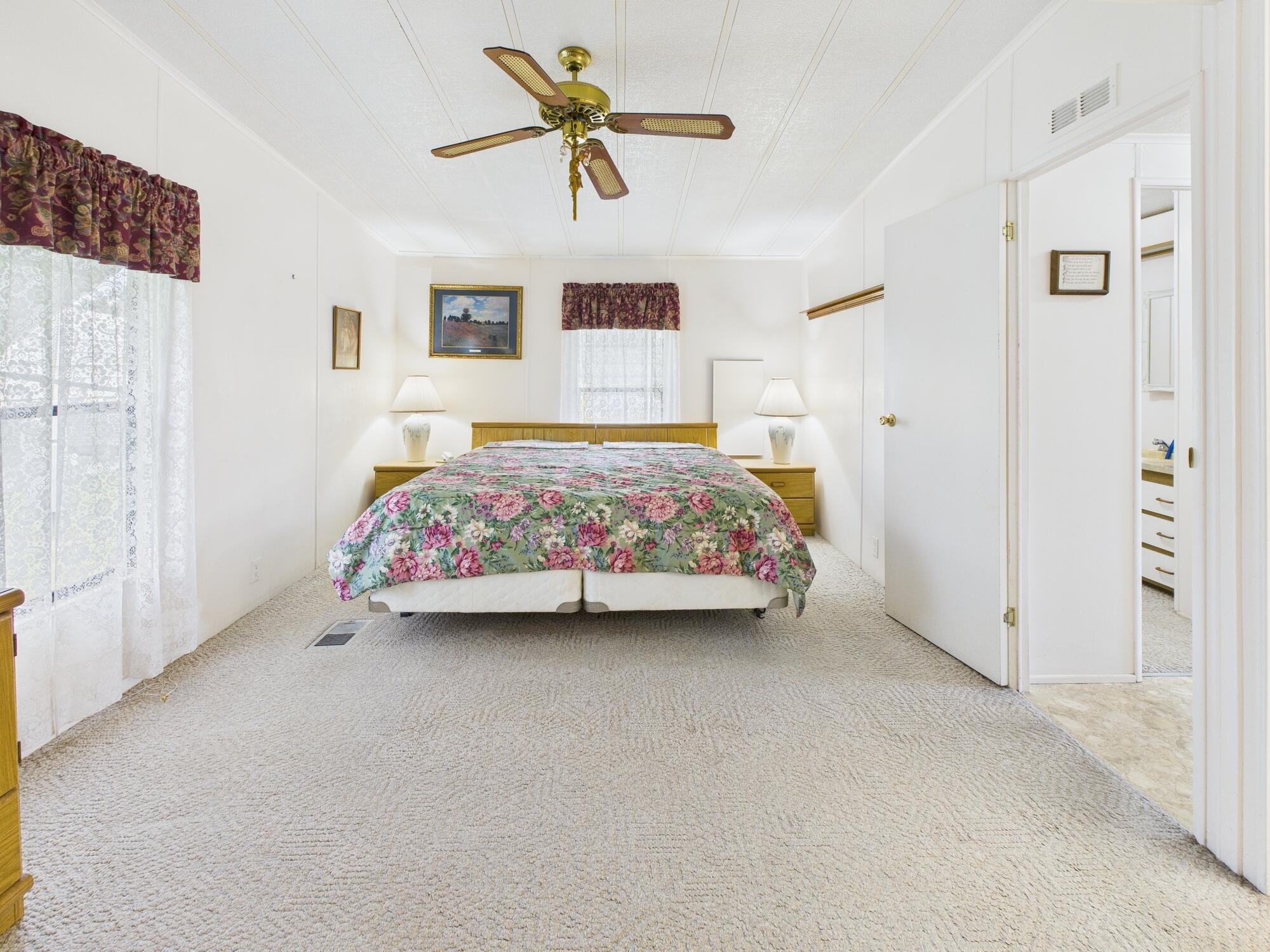 2001 Southeast 27th Street Okeechobee, FL 34974 - Photo 38 of 57 a bedroom with a bed a chandelier and a window