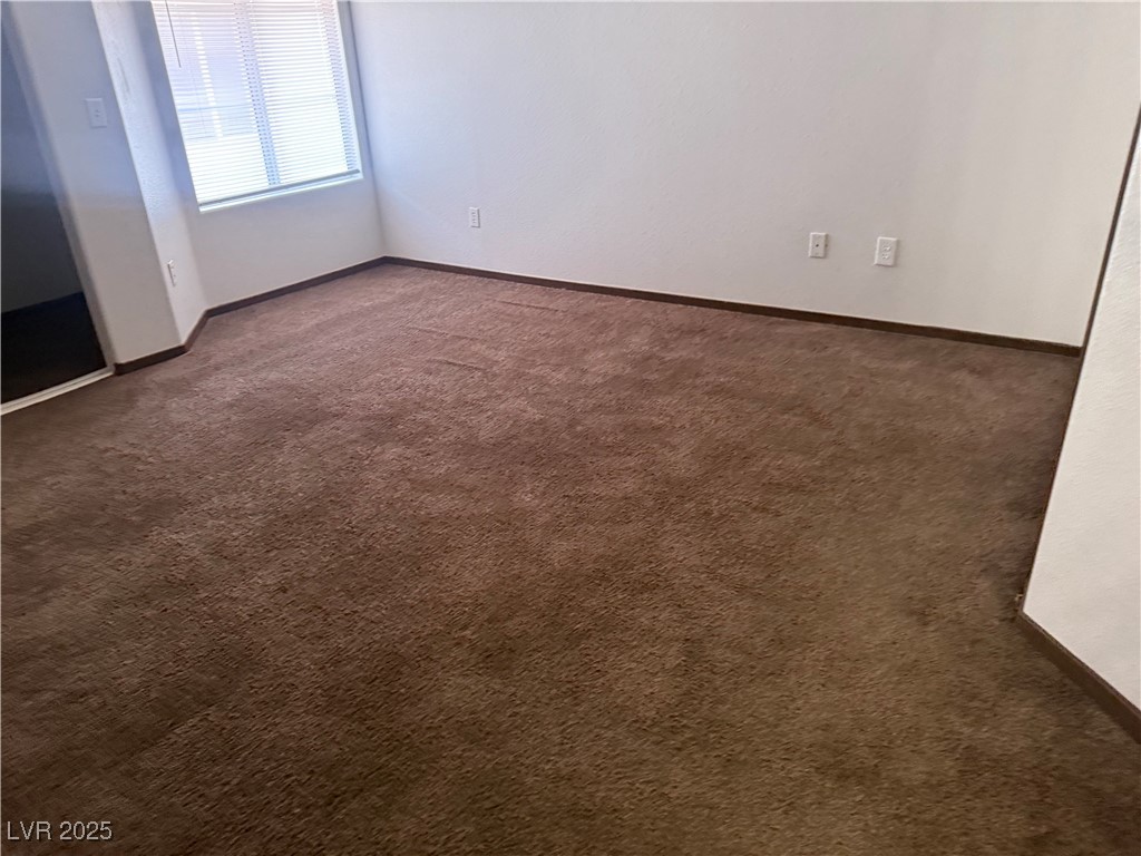 4500 West Lake Mead Boulevard, Unit 202 Las Vegas, NV 89108 - Photo 17 of 19 Empty room with dark colored carpet and baseboards