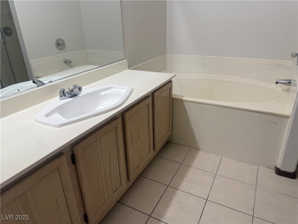 4500 West Lake Mead Boulevard, Unit 202 Las Vegas, NV 89108 - Photo 19 of 19 Full bath featuring vanity, light tile patterned floors, and a garden tub