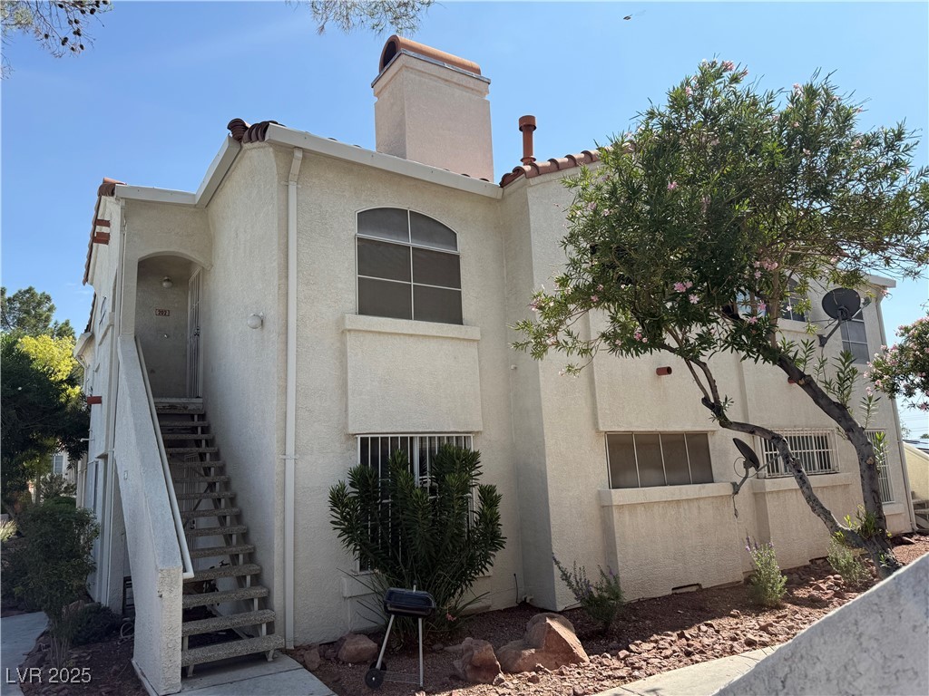4500 West Lake Mead Boulevard, Unit 202 Las Vegas, NV 89108 - Photo 2 of 19 View of front of property with stairway, stucco siding, and a chimney