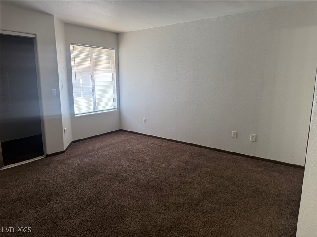 4500 West Lake Mead Boulevard, Unit 202 Las Vegas, NV 89108 - Photo 3 of 19 Unfurnished bedroom featuring dark colored carpet and baseboards