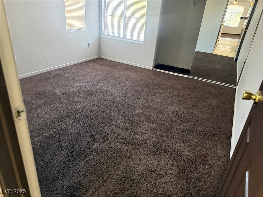 4500 West Lake Mead Boulevard, Unit 202 Las Vegas, NV 89108 - Photo 4 of 19 Unfurnished bedroom featuring dark colored carpet and a closet
